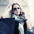 Fashion business woman in sunglasses talking on cell phone leaning on car door Royalty Free Stock Photo