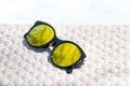 Fashion cat eye sunglasses for ladies with big round yellow lenses and black frame shoot outside in a sunny day closeup