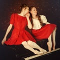 Fashion caucasian ballerinas sitting on the piano and laughing