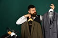 Fashion choice. Man with beard in vest by clothes rack