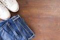 Close up of jeans pants and sneakers on wooden background