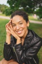 Fashion close up portrait of attractive young natural beauty African American woman with afro hair in black leather Royalty Free Stock Photo