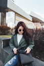 Fashion closeup portrait of nice pretty young hipster woman posing in sunglasses Outdoor .Brunette happy girl in green Royalty Free Stock Photo