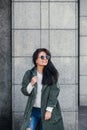 Fashion closeup portrait of nice pretty young hipster woman posing in sunglasses Outdoor .Brunette happy girl in green Royalty Free Stock Photo