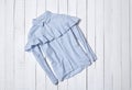 Fashion clothes. Blue and white striped shirt with flounce on white wooden floor planks