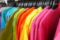 Fashion clothes on clothing rack - bright colorful closet. Close-up of rainbow color choice of trendy female wear