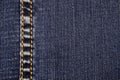 An element of jeans clothes. A seam of yellow thread on the left