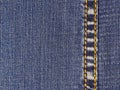 An element of jeans clothes. A seam of yellow thread on right.