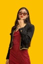 Fashion concept, Fashionable woman wear sunglasses to posing in mini red dress and black jacket Royalty Free Stock Photo