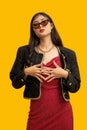 Fashion concept, Fashionable woman wear sunglasses to posing in mini red dress and black jacket Royalty Free Stock Photo