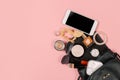 Fashion concept : Flat lay of brown leather woman bag open out with cosmetics, accessories and smartphone on pink background