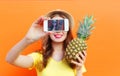 Fashion cool girl with pineapple taking picture self portrait on smartphone over colorful Royalty Free Stock Photo