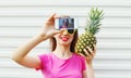 Fashion cool girl with pineapple taking picture self portrait on smartphone Royalty Free Stock Photo