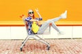 Fashion cool smiling girl having fun sitting in shopping trolley cart Royalty Free Stock Photo