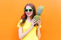 Fashion cool smiling girl in sunglasses with pineapple over colorful orange Royalty Free Stock Photo