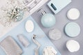 Fashion cosmetic products set on pastel blue, grey color paper - white soap, towel, flowers, soap dispenser, blue ceramic vase. Royalty Free Stock Photo