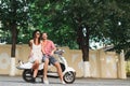 Fashion couple embracing on scooter