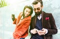 Fashion couple having fun together with mobile smart phone - Beginning of love story with hipster best friends on mobile phone - Royalty Free Stock Photo