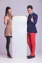 Fashion couple holding a white board Royalty Free Stock Photo