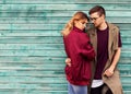 Fashion couple in their glasses with burgundy clothes posing on