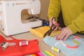 Fashion designer cutting textile next to a sewing machine