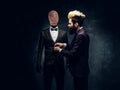 A fashion designer with expressive style working with custom made men`s suit in a dark tailor studio Royalty Free Stock Photo