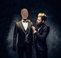 A fashion designer with expressive style working with custom made men`s suit in a dark tailor studio Royalty Free Stock Photo