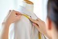 Fashion designer measures jacket with tape measure Royalty Free Stock Photo