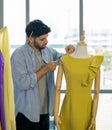 Fashion designer room. The men`s dressmaker using tape measure measuring the shoulder size of dress on the mannequin Royalty Free Stock Photo