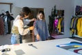 Fashion designer woman takes measurements with measuring tape of client before tailoring clothes Royalty Free Stock Photo