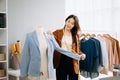 Fashion designer woman talking smart phone and using laptop with digital tablet computer in modern studio the clothes hanging on Royalty Free Stock Photo