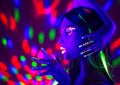 Fashion disco woman. Dancing model in neon light, portrait of beauty girl with fluorescent makeup Royalty Free Stock Photo