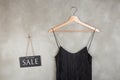 Fashion discount concept - blackboard with text Sale and beautiful little black dress on a hanger