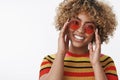 Fashion diva ready for walk. Good-looking stylish and happy african american girl with blond curly hair in trendy round Royalty Free Stock Photo