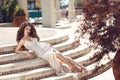 Fashion elegant lady in dress lying on steps. Beautiful young br