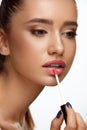 Fashion Female Model With Beauty Face Applying Lip Balm On Lips