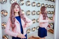 Fashion freak. Glamour synthetic girl, fake doll with empty look and long lilac hair is sitting in the studio. Stylish Royalty Free Stock Photo