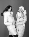 Fashion friends. Winter season. Soft fur. For those wishing stay modern. Winter clothes. Women wear down jacket with