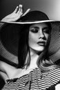 Fashion girl in a big hat in the studio. Black and white Royalty Free Stock Photo