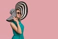 Fashion girl in a big hat and sunglasses on a colored background. Royalty Free Stock Photo