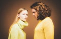 Fashion girl and guy in outlet yellow clothes posing in studio. Fashion couple each other.