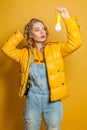 Fashion girl holding light bulb on yellow background Royalty Free Stock Photo