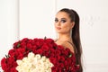 Fashion girl holds luxury big bouquet of roses. Perfect sensual lips. Fashion makeup. Valentine day 101 roses for you