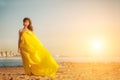 Fashion girl in a long dress against a summer sunset background. Royalty Free Stock Photo