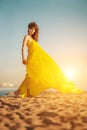 Fashion girl in a long dress against a summer sunset background. Royalty Free Stock Photo