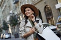 Fashion girl. Portrait of a young beautiful stylish woman in hat with shopping bag looking aside and smiling while Royalty Free Stock Photo