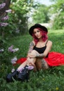 Fashion girl with red hair and big hat, spring portrait in lilac colors in summer. Beautiful red pink dress, tattoos on the body Royalty Free Stock Photo