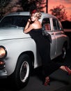 Fashion girl in retro style posing near old car Royalty Free Stock Photo