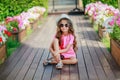 Fashion girl wearing a pink checkered shirt, hat and sunglasses in city Royalty Free Stock Photo