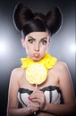 Fashion girl with yellow lollipop and smile agains